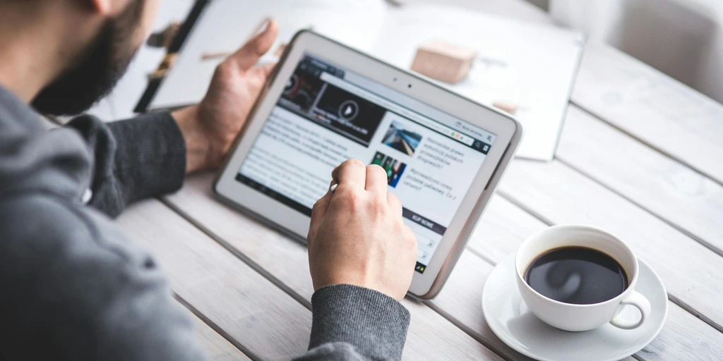 Mann mit Tablet und Kaffee